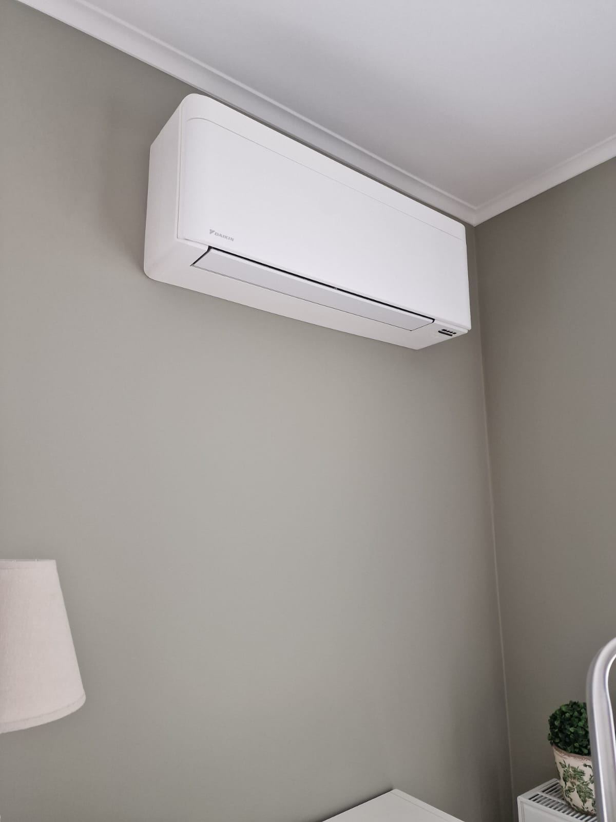 Unité murale Daikin Emura blanche installée dans une chambre