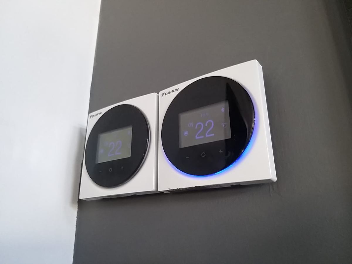 Deux thermostats connectés Daikin installés au mur